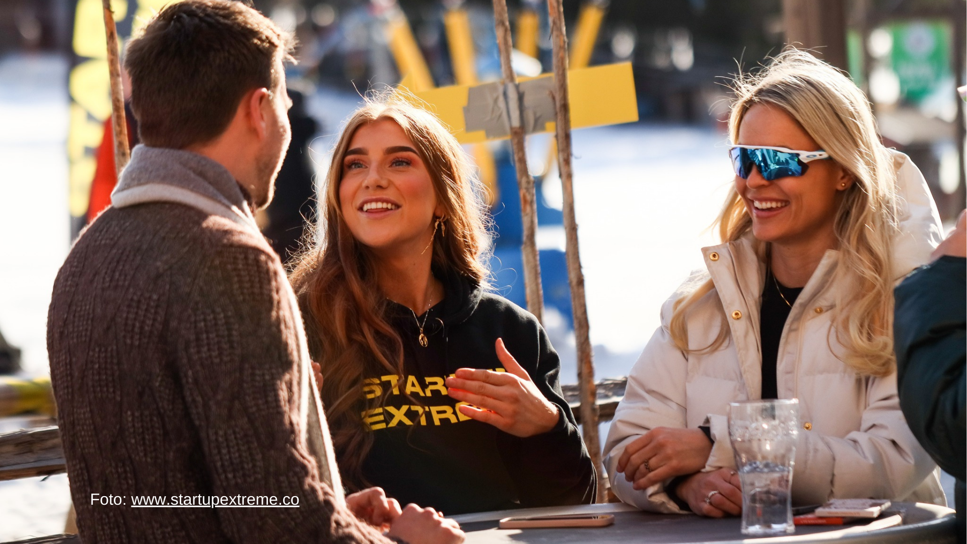 Bilete av tre blide personar som pratar.